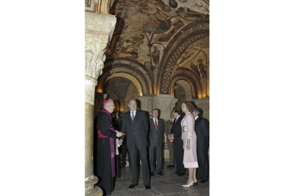 Los Reyes, en el Panteón Real isidoriano, siguiendo atentamente las explicaciones del obispo.