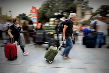 Una pareja con sus maletas y mochilas, ayer en una calle de Barcelona.