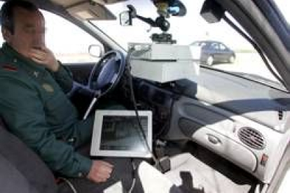 Un guardia civil observa el dispositivo de radar dentro del vehículo