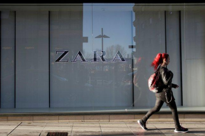 Una mujer camina junto a una tienda de Zara en Pontevedra.