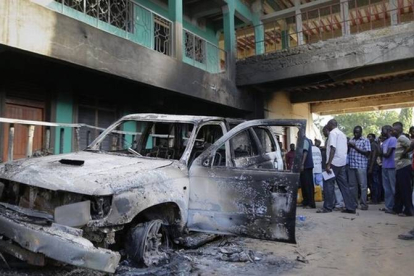 Residentes locales se reúnen en el incendiado Hotel de la Granja, tras el ataque terrorista en Mpeketoni, este lunes.