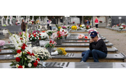 Una mujer acompaña a su familiar en el día de los difuntos en el cementerio de León