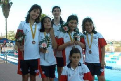 Las jóvenes nadadoras leonesas posan junto a las medallas conseguidas.
