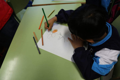 Un niño realiza un dibujo en las tareas de apoyo escolar y meriendas que los voluntarios de Cruz Roja llevan a cabo. SECUNDINO PÉREZ