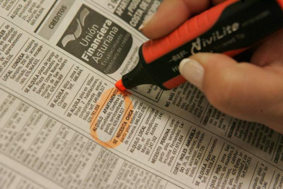 Una mujer señala un anuncio de alquiler de un apartamento en el periódico.