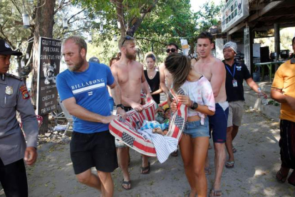 Turistas ayudan a una mujer herida tras el terremoto que sacudió la isla de Lombok. ADI WEDA