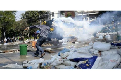 Manifestantes atacan a la policía en las inmediaciones de la sede del Gobierno tailandés en Bangkok.