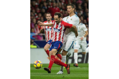 El delantero portugués del Madrid Cristiano Ronaldo pelea un balón con el defensa del Atlético Juanfran Torres. RODRIGO JIMÉNEZ