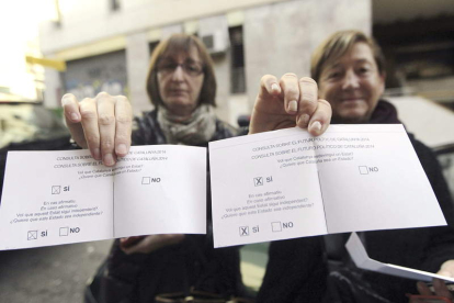 Dos mujeres muestran sus papeletas en la jornada participativa.