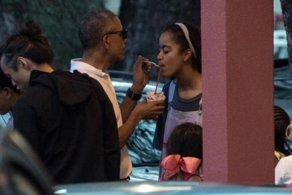 Obama da a su hija Malia un poco de su granizado, la pasada Nochebuena en Kailua (Hawai).