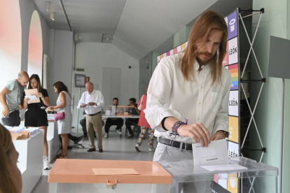 El portavoz nacional de Podemos Pablo Fernández (d) ejerce su derecho al voto en un colegio electoral de León. J. CASARES