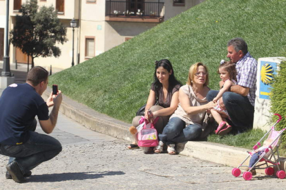 Un grupo de visitantes se fotografía en pleno Camino de Santiago junto a las puertas del castillo templario ponferradino.