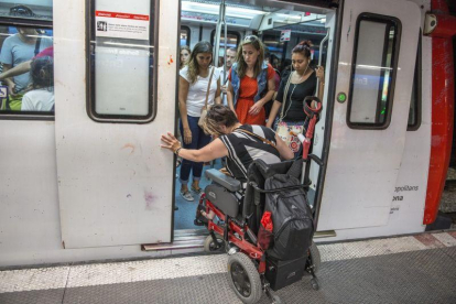Una mujer en silla de ruedas intenta acceder al vagón del metro