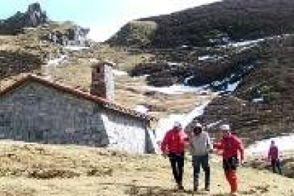 El montañero, con los dos agentes a la salida del refugio del Frade