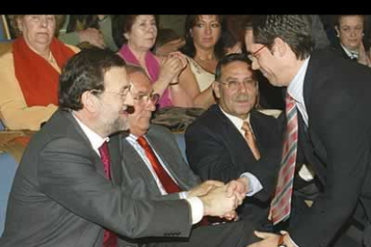 El secretario general del PP en León, José María López Benito, saluda al candidato.
