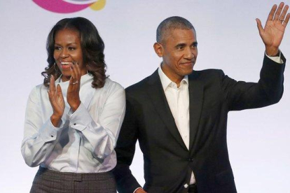 El matrimonio Obama posa sonriente tras firmar el acuerdo con con la plataforma de música en streaming Spotify.