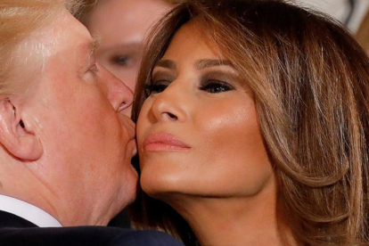 Melania Trump recibe un beso de Donald Trump en la Casa Blanca.