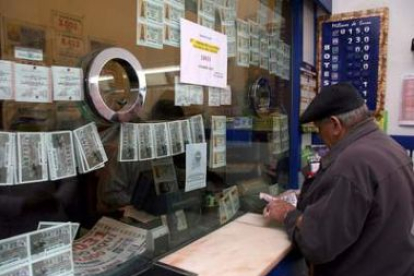 Un hombre sella su boleto de apuestas en una oficina de lotería.