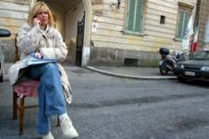 La nieta de Mussolini habla por teléfono sentada en una calle de Roma