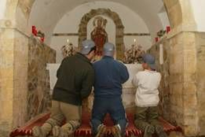 Imagen de tres niños rezando en una ermita de la Valdorria