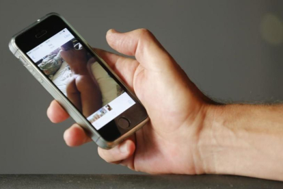 Un hombre mira una fotografía porno en el móvil.