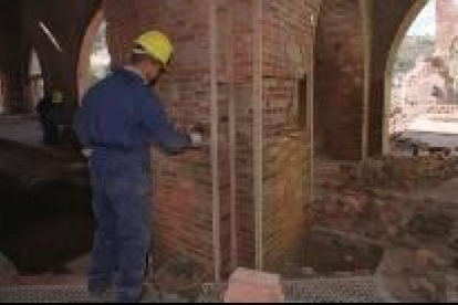 Un operario trabaja en las obras de restauración de un edificio en un pueblo de la provincia de León