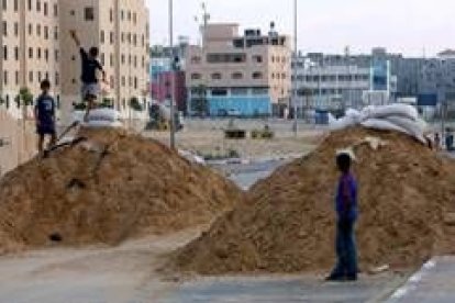 Niños palestinos juegan sobre trincheras de arena preparadas ante un posible ataque