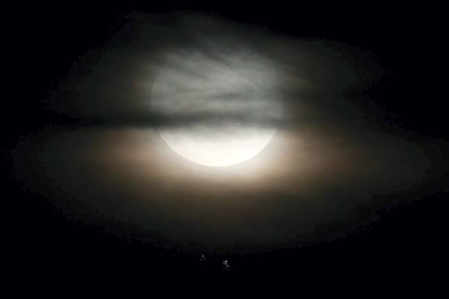 Un avión cruza los cielos mientras la superluna se eleva en el firmamento de Río de Janeiro (Brasil), el 10 de agosto de 2014. MARIO TAMA | AFP