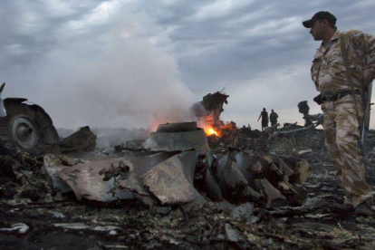 Un miliciano observa parte de los restos del avión de Malaysia Airlanes.