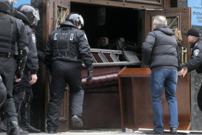 Un grupo de policías fuerzan una puerta en las dependencias ocupadas en Donetsk por activitas prorrusos, este sábado.