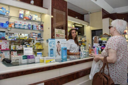 Una clienta compra medicamentos en una farmacia.