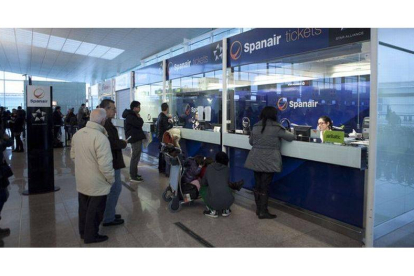 Pasajeros de Spanair, ante los mostradores de la compañía, el sábado, en el aeropuerto de El Prat.