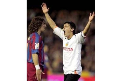 David Villa celebra el gol que hizo a Valdés mientras Puyol pone cara de circunstancias
