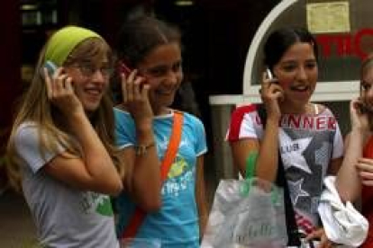 En la imagen, un grupo de jóvenes españolas hablando por el teléfono móvil