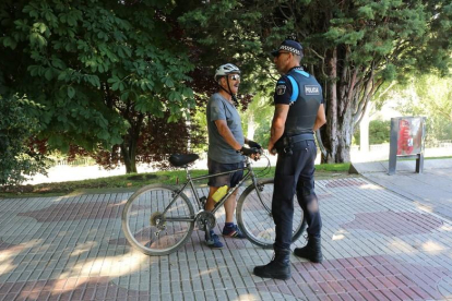 Un agente informa a un ciclista de la nueva ordenanza que prohíbe circular por las aceras.