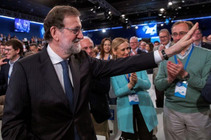 Mariano Rajoy, junto a la presidenta de la Comunidad de Madrid, Cristina Cifuentes, y al presidente del PP vasco, Alfonso Alonso, saluda a los asistentes a la convención, este domingo.