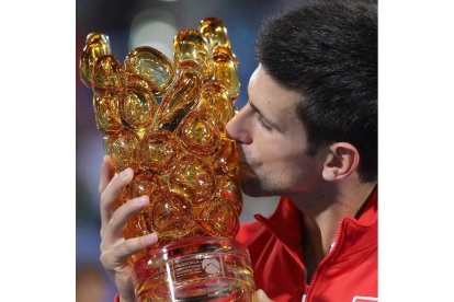 El tenista serbio besa el trofeo de ganador en Abu Dabi tras derrotar a Ferrer en la final.