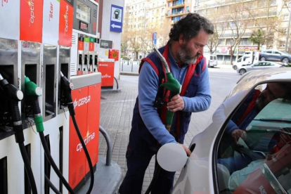 Un conductor repostan en la gasolinera de Barcelona.