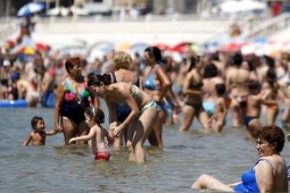 Centenares de personas se refrescan en la playa.