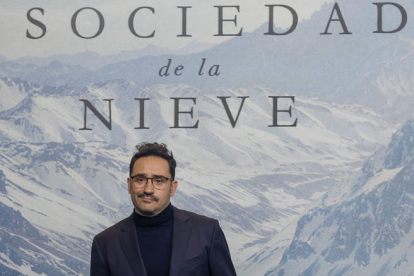 El director de ‘La sociedad de la nieve’, Juan Antonio Bayona, ante el cartel de la película. JAVIER LIZÓN