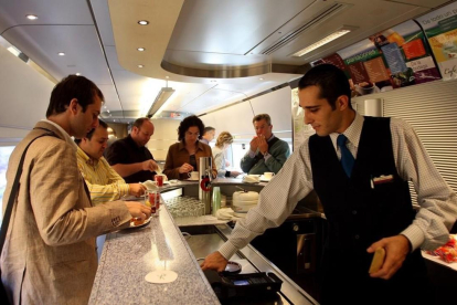 Un camarero sirve a un cliente en el bar de un tren AVE.