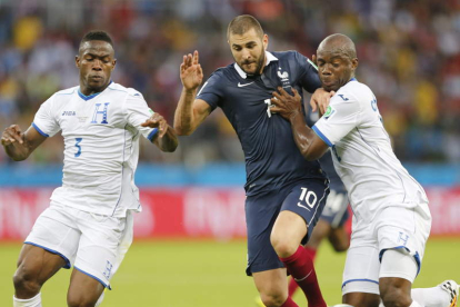 Benzema intenta escaparse de dos defensores. El delantero galo fue letal frente a Honduras.