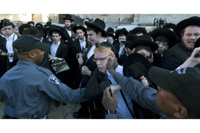 La policía israelí intenta contener a judíos ultraotodoxos en la plaza del Muro de las Lamentaciones en Jerusalén.