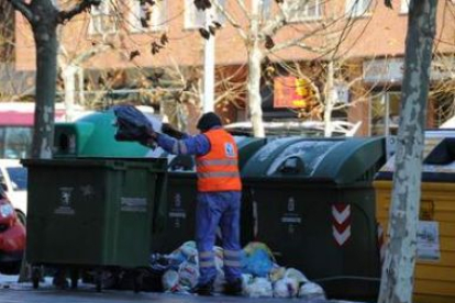 Un operario de la concesionaria de limpieza retira basura en la calle.
