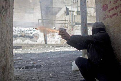Un palestino lanza un petardo a las fuerzas de seguridad israelís.
