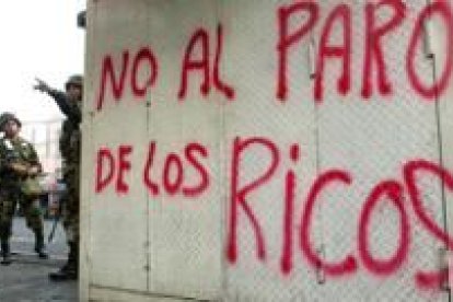 Militares venezolanos junto a una de las pintadas realizadas en la jornada de huelga