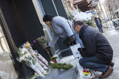 Dos neoyorquinos dejan flores ante el edificio de apartamentos donde vivía Philip Seymour Hoffman, este martes.