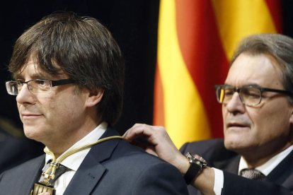 Mas impone la medalla representativa del cargo al nuevo presidente, Puigdemont.