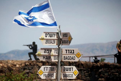 Un soldado israelí junto a un grupo de carteles que indican las distancias entre los Altos del Golán y varias ciudades de Oriente Próximo.