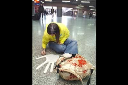 Una joven firma en una gran mano blanca en el suelo de la estación de Atocha. Las estaciones de las que partieron y a la que llegaron los trenes serán escenario de homenajes a las víctimas.